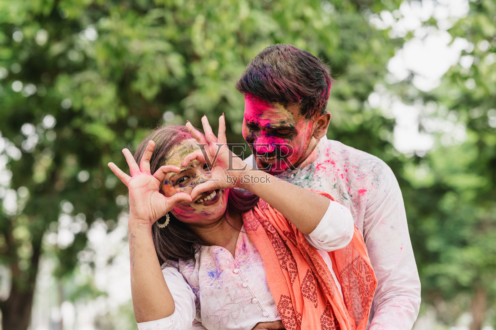 快乐有趣的亚洲/印度夫妇涂上色彩庆祝洒红节照片摄影图片