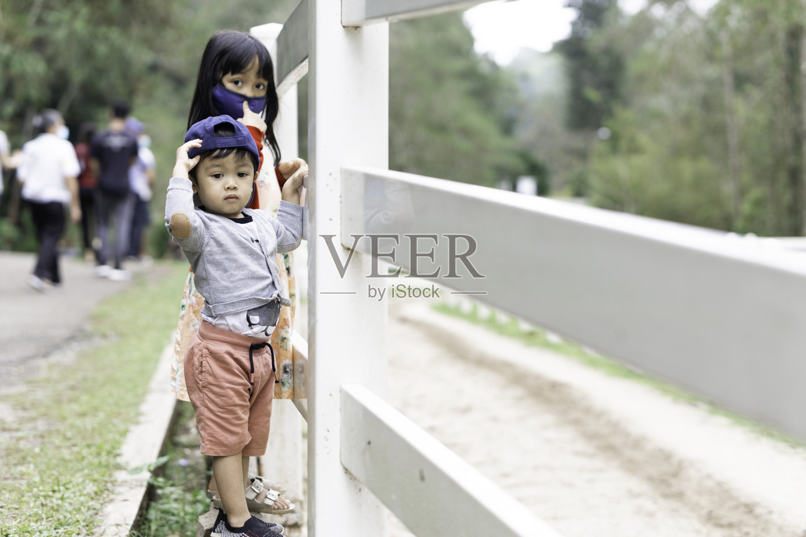 孩子们站在马场附近，在阳光灿烂的天空下照片摄影图片