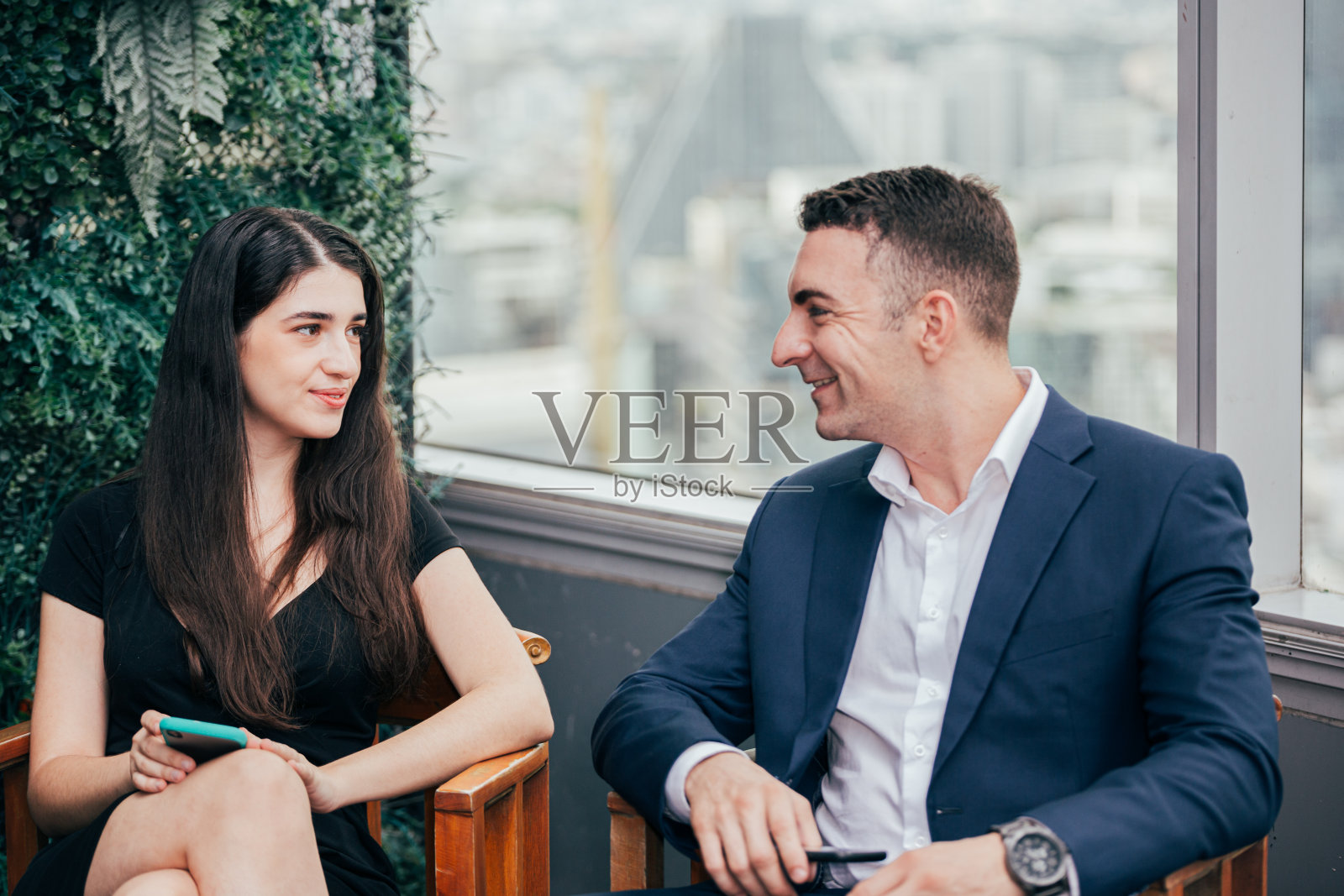 商务人士喜欢坐在办公室里聊天。商人和女商人下班后见面。与合作伙伴或同事分享信息。照片摄影图片