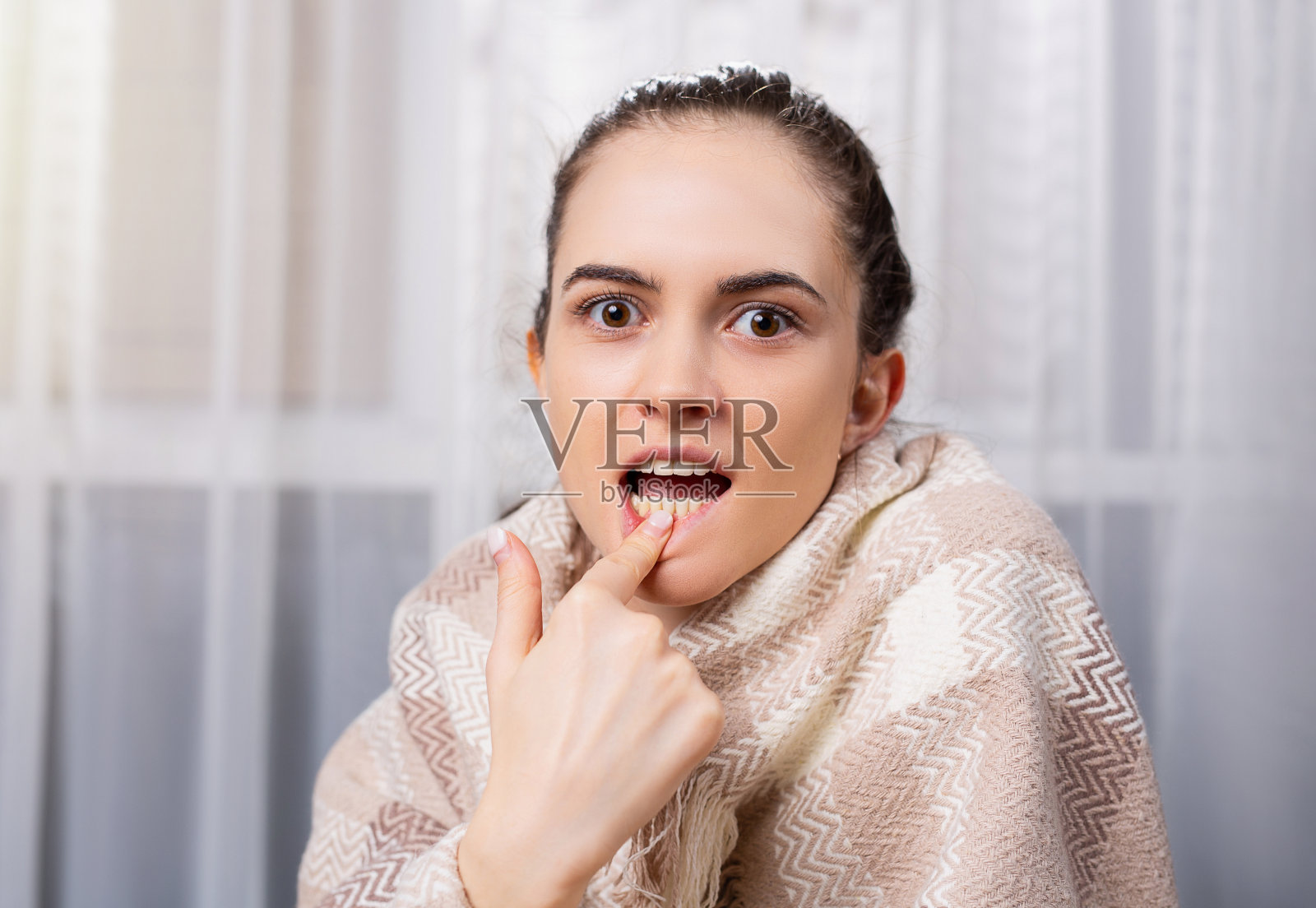 一位牙疼的年轻女子绝望地看着镜头。一名牙齿疼痛的女性病人在网上牙科诊所就诊。牙科和口腔护理照片摄影图片