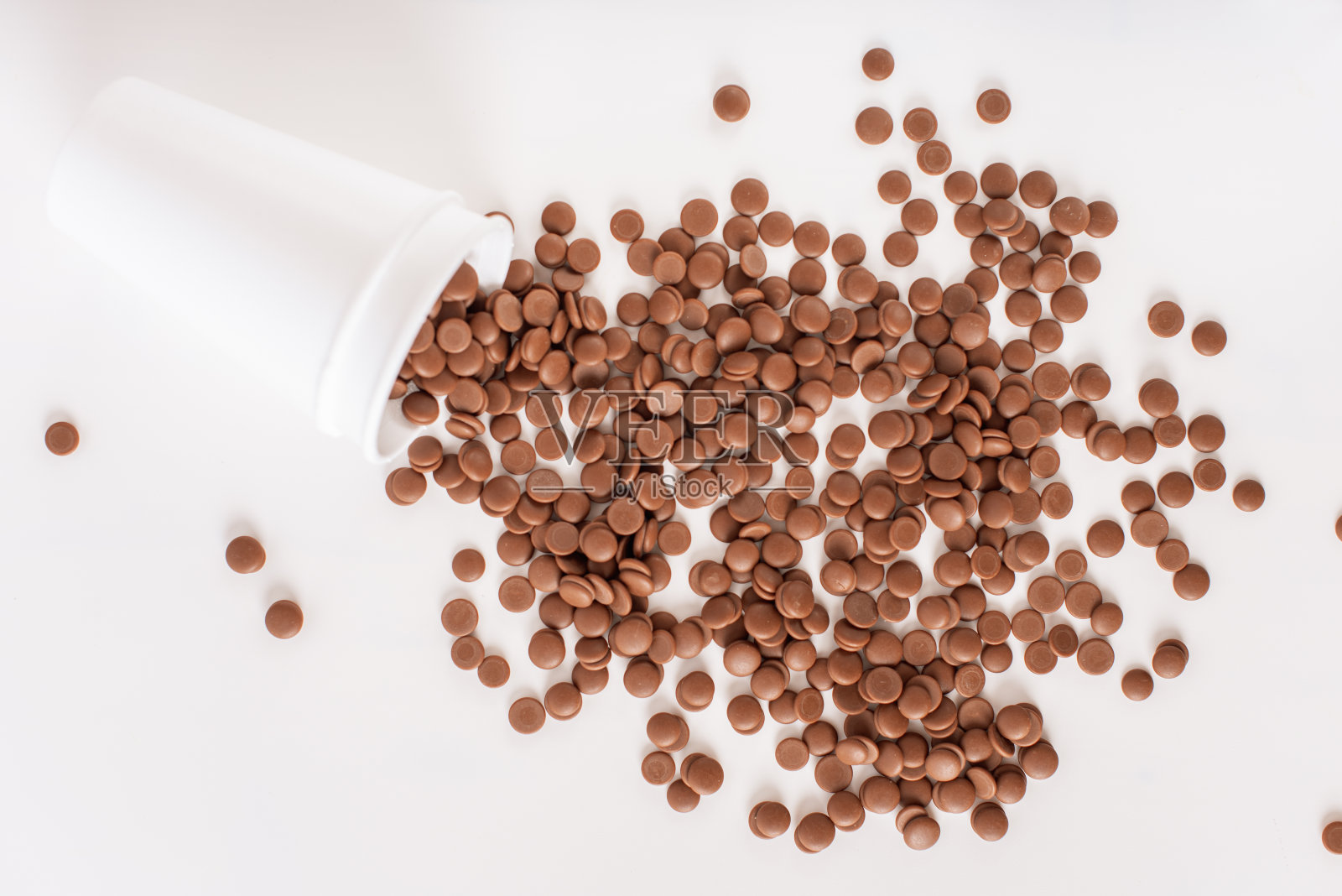 DIY自制的糖果。家庭糖果商的经营理念。在白色背景上，一次性杯子上散落着巧克力屑。顶视图特写。平的。照片摄影图片