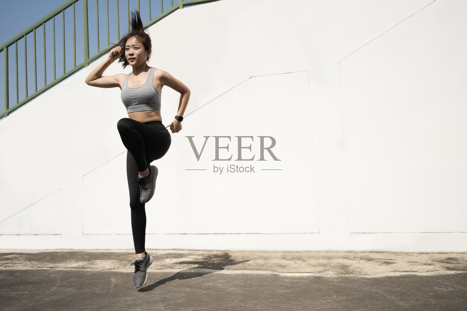 早上穿着运动服在户外做有氧运动的女人。照片摄影图片