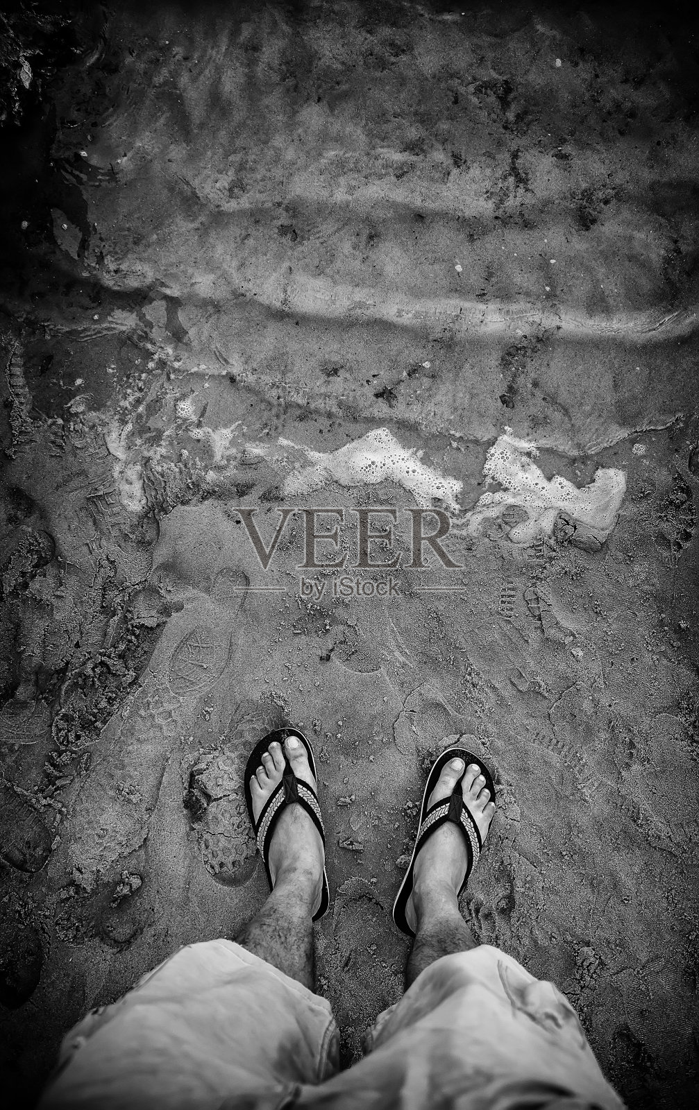 穿着人字拖的脚在沙滩上照片摄影图片