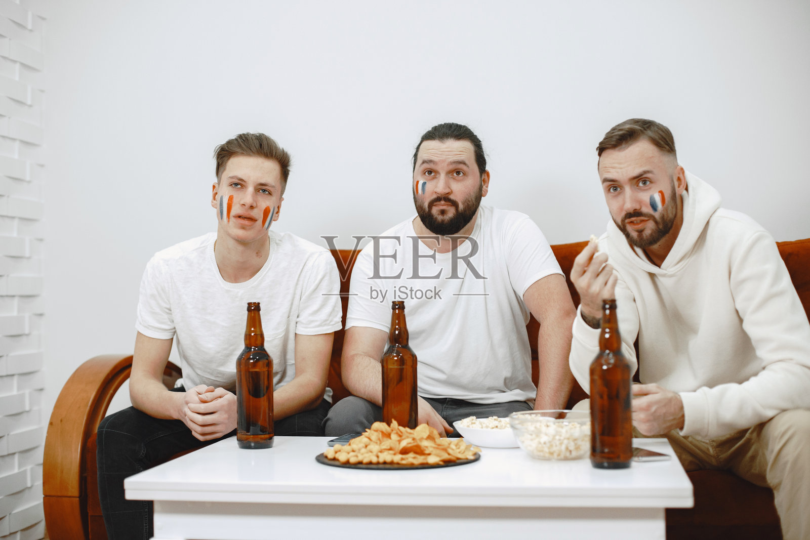 一群球迷正在电视上观看足球比赛照片摄影图片