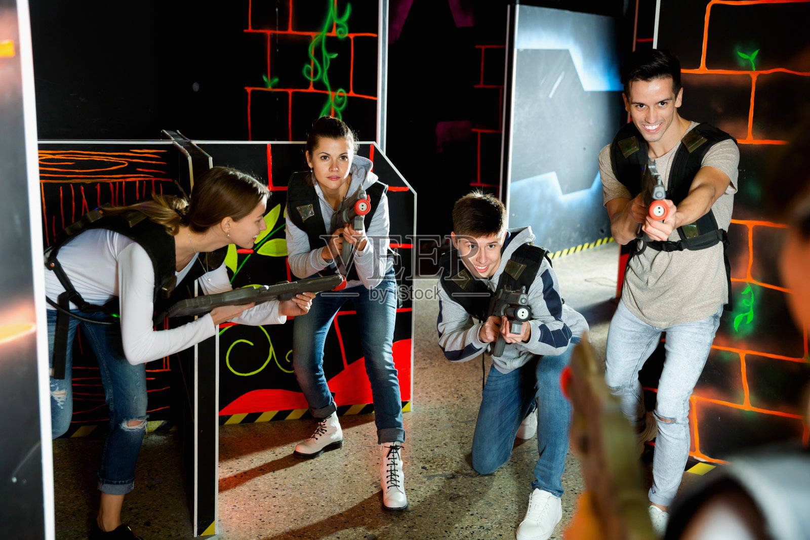 普通的激光枪战队员，年轻的男女在黑暗的激光枪战站比赛照片摄影图片