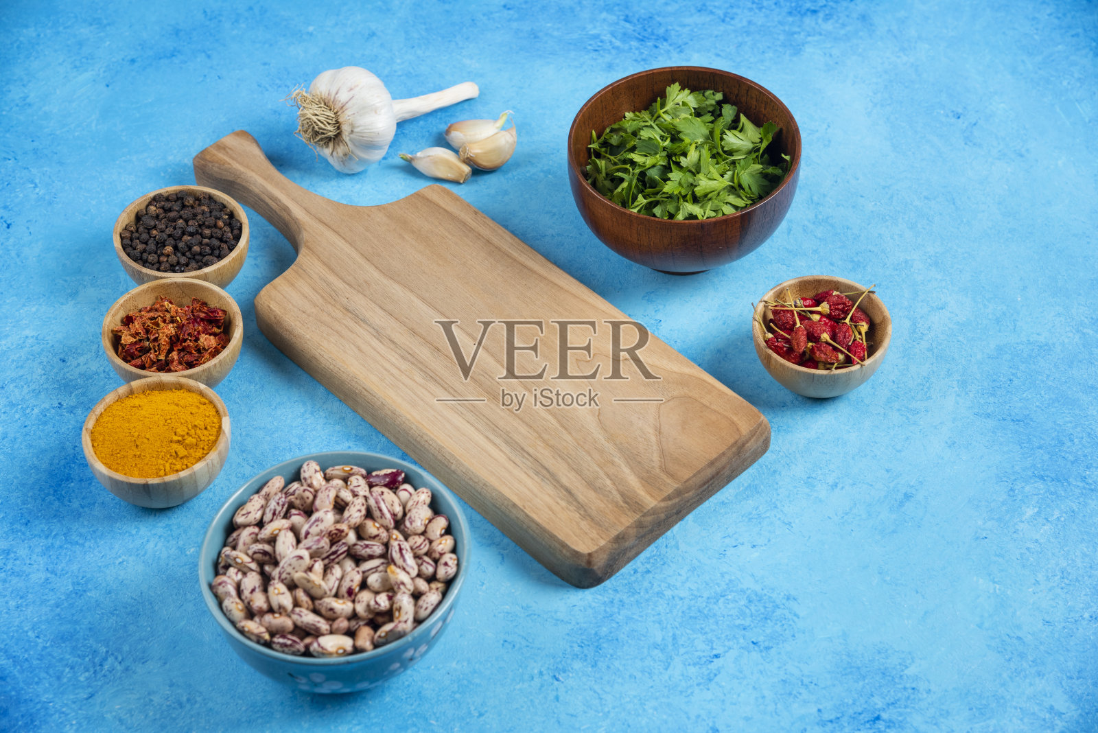 蓝色背景的生豆子和有机香料碗照片摄影图片