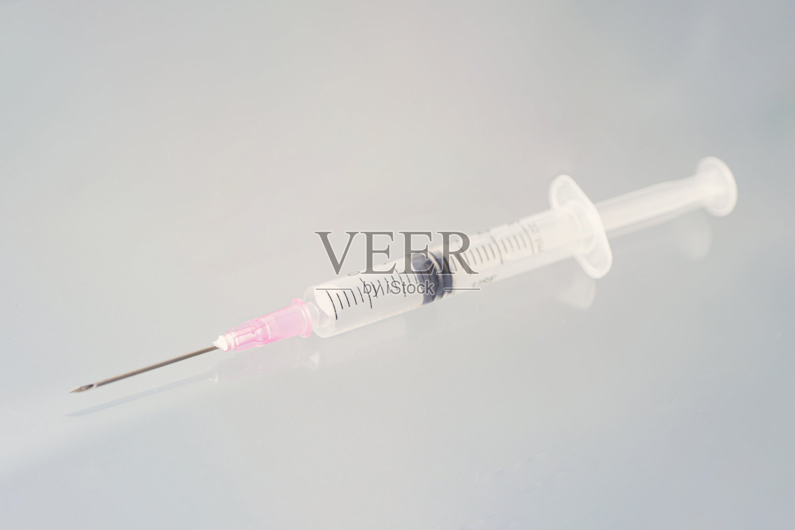 桌上有粉红色针头和注射器。副本的空间。医学概念。照片摄影图片