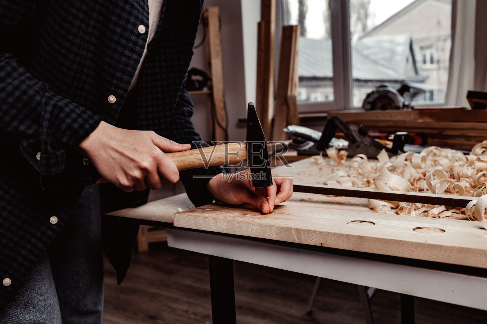人的手把钉子钉进木条里照片摄影图片