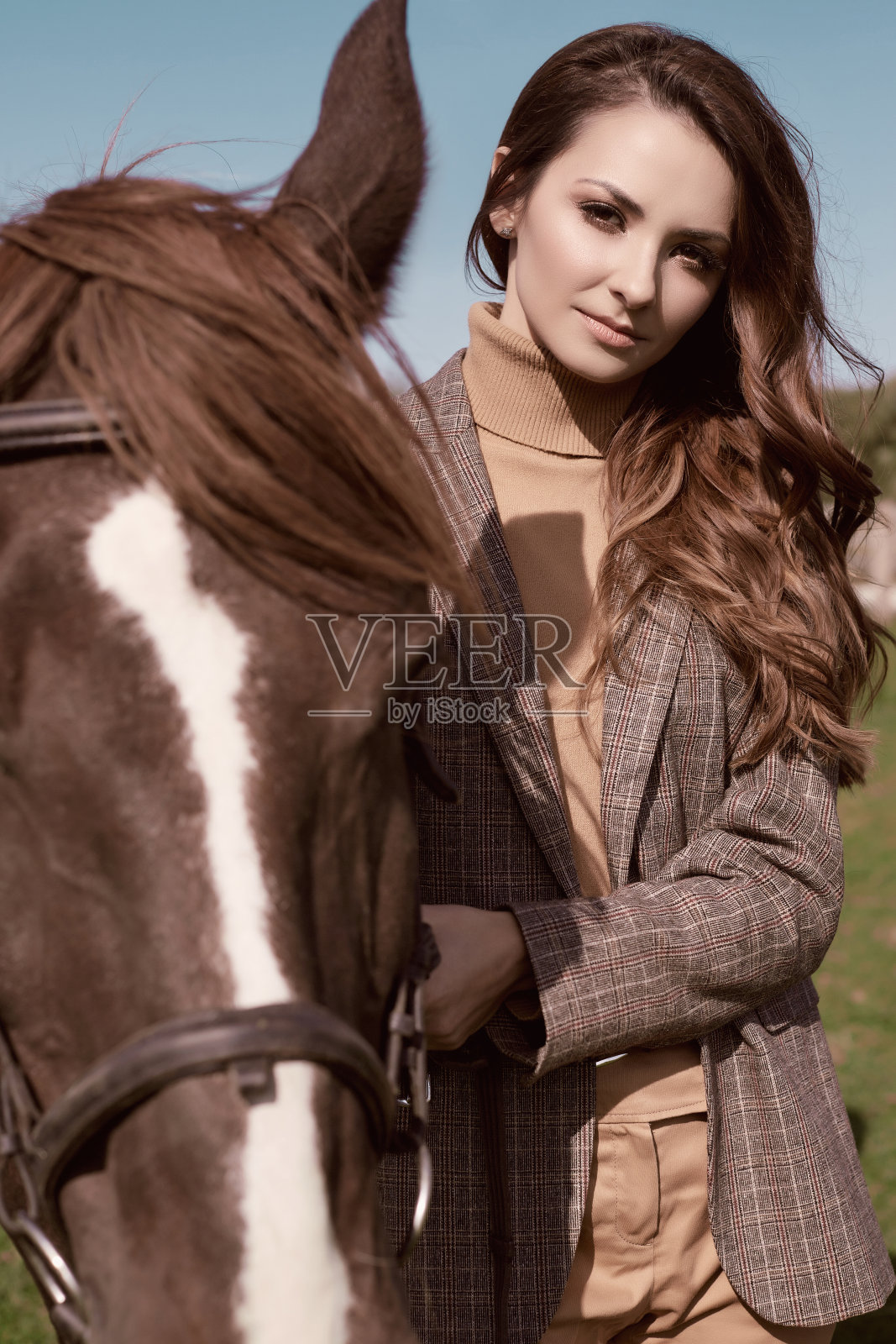漂亮的黑发女人穿着优雅的格子夹克和一匹马照片摄影图片