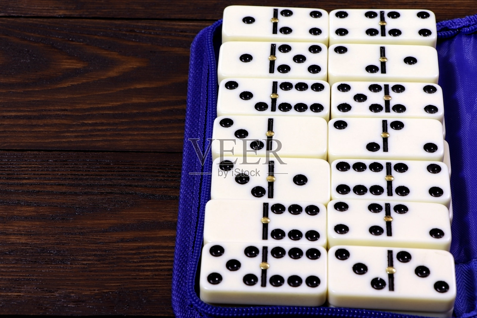 多米诺骨牌游戏在一张木桌上，棕色的背景。棋盘游戏domino。赌博。照片摄影图片