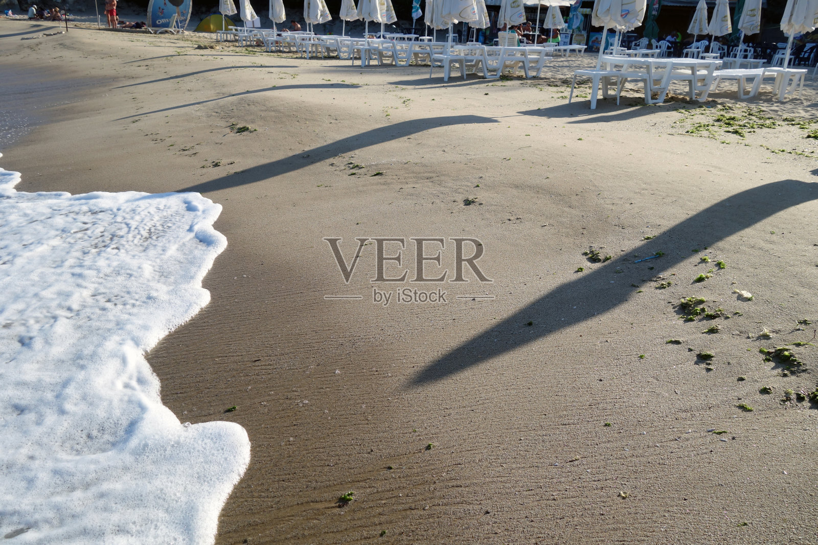 沙滩上遮阳伞的影子。照片摄影图片