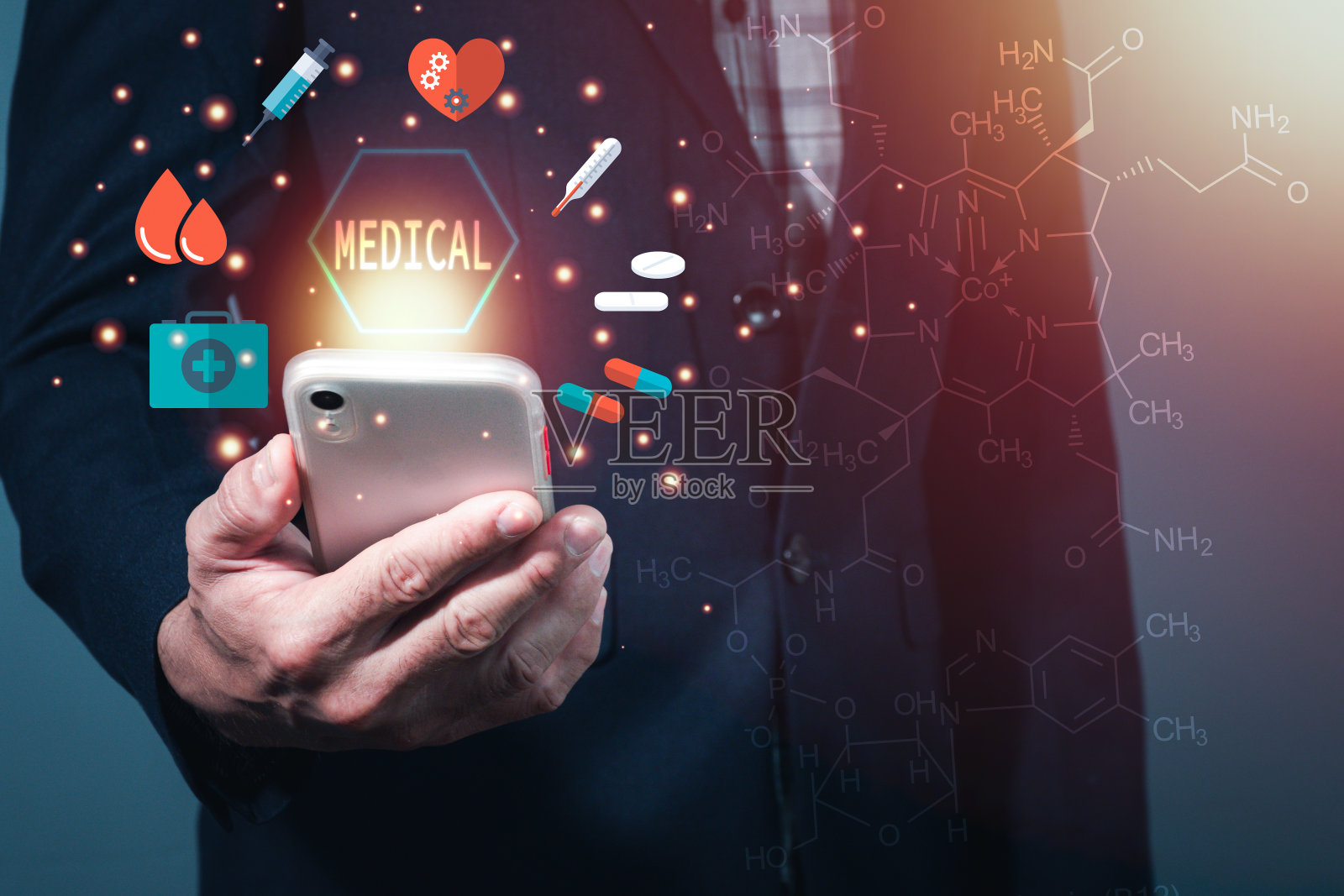 一个男人穿着西装，拿着手机，屏幕上有光，还有医学和健康的标志。背景是一种化学键。照片摄影图片