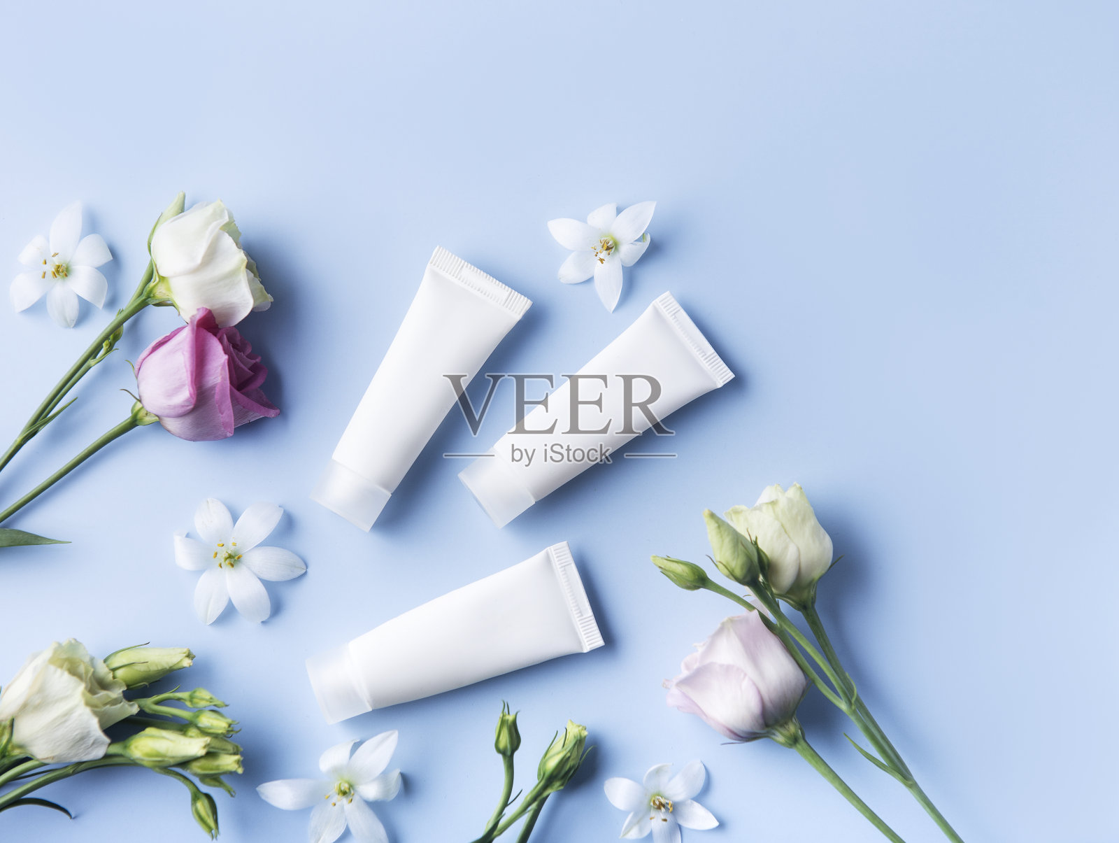 蓝色背景上的白色奶油管照片摄影图片