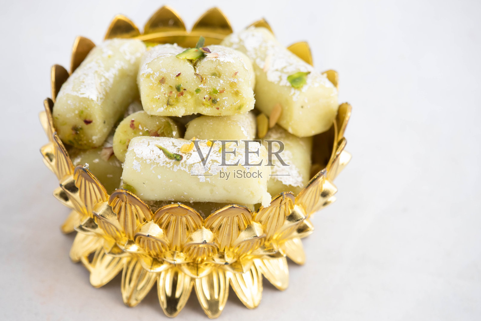 特别Kaju Pistachio Roll或腰果开心果卷Mithai是由磨碎的腰果与碎Khoya Mawa Kesar Mava Elaichi Khoa在Desi酥油和焯过的杏仁和干果照片摄影图片