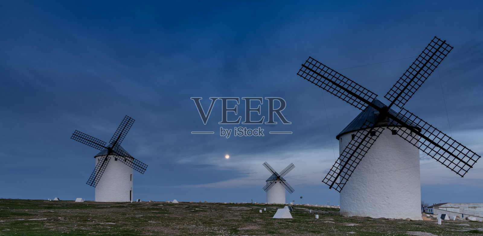 在满月的夜晚，拉曼查的白色风车在坎波德克里塔纳镇上空照片摄影图片