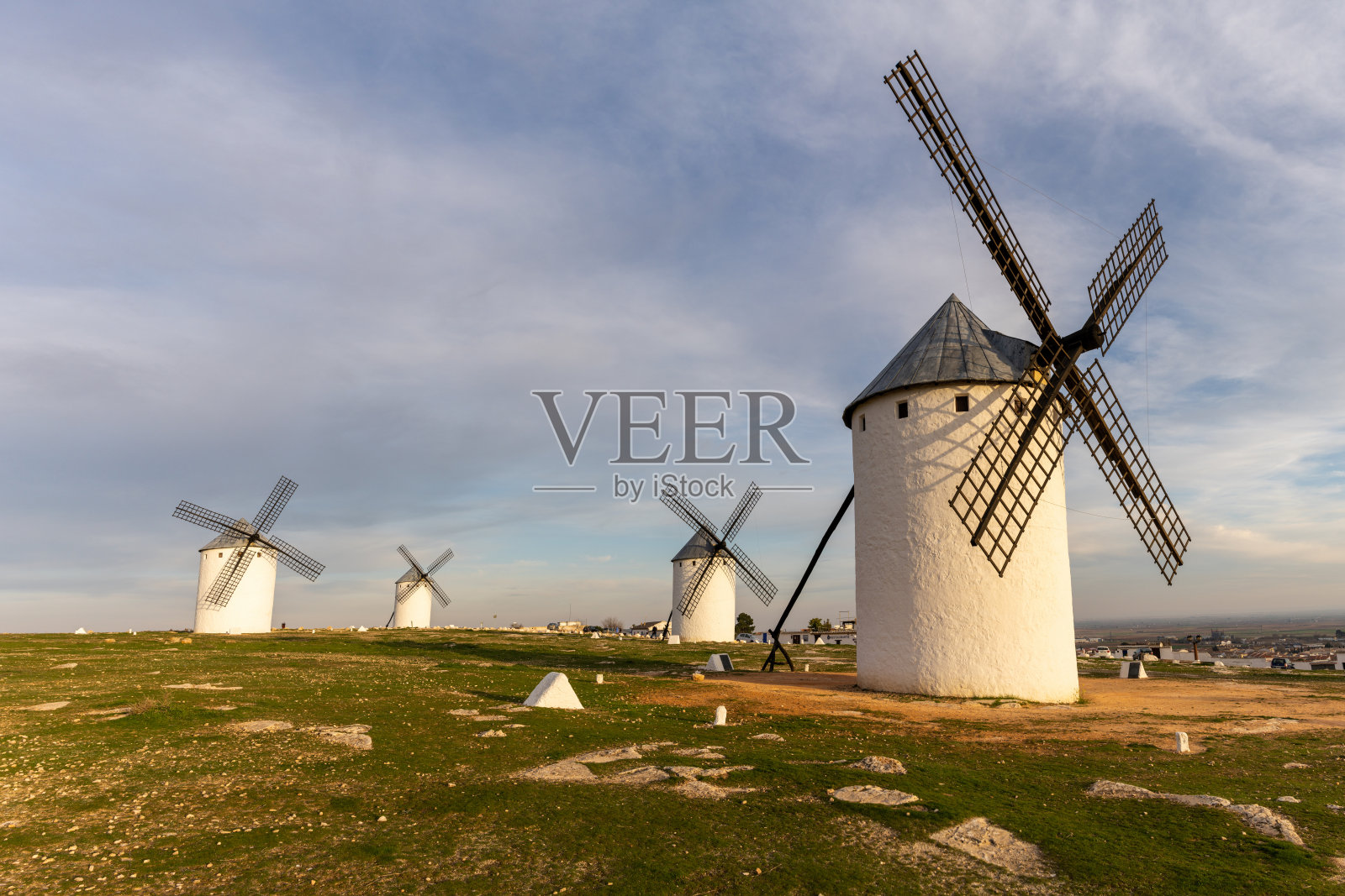 在温暖的夜晚，拉曼查的白色风车在坎波德克里塔纳镇上空照片摄影图片