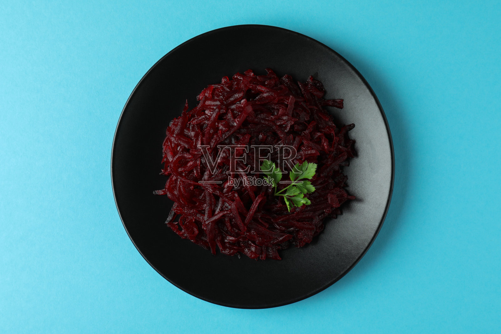 盘子上有新鲜的甜菜沙拉，蓝色背景，俯视图照片摄影图片