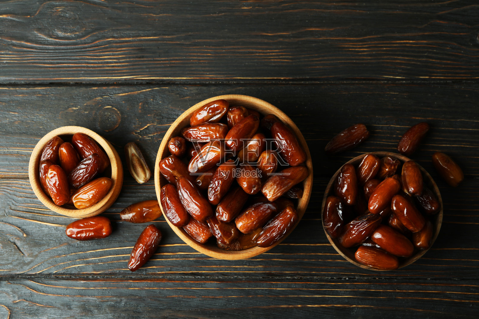 木桌上放着干枣的碗照片摄影图片