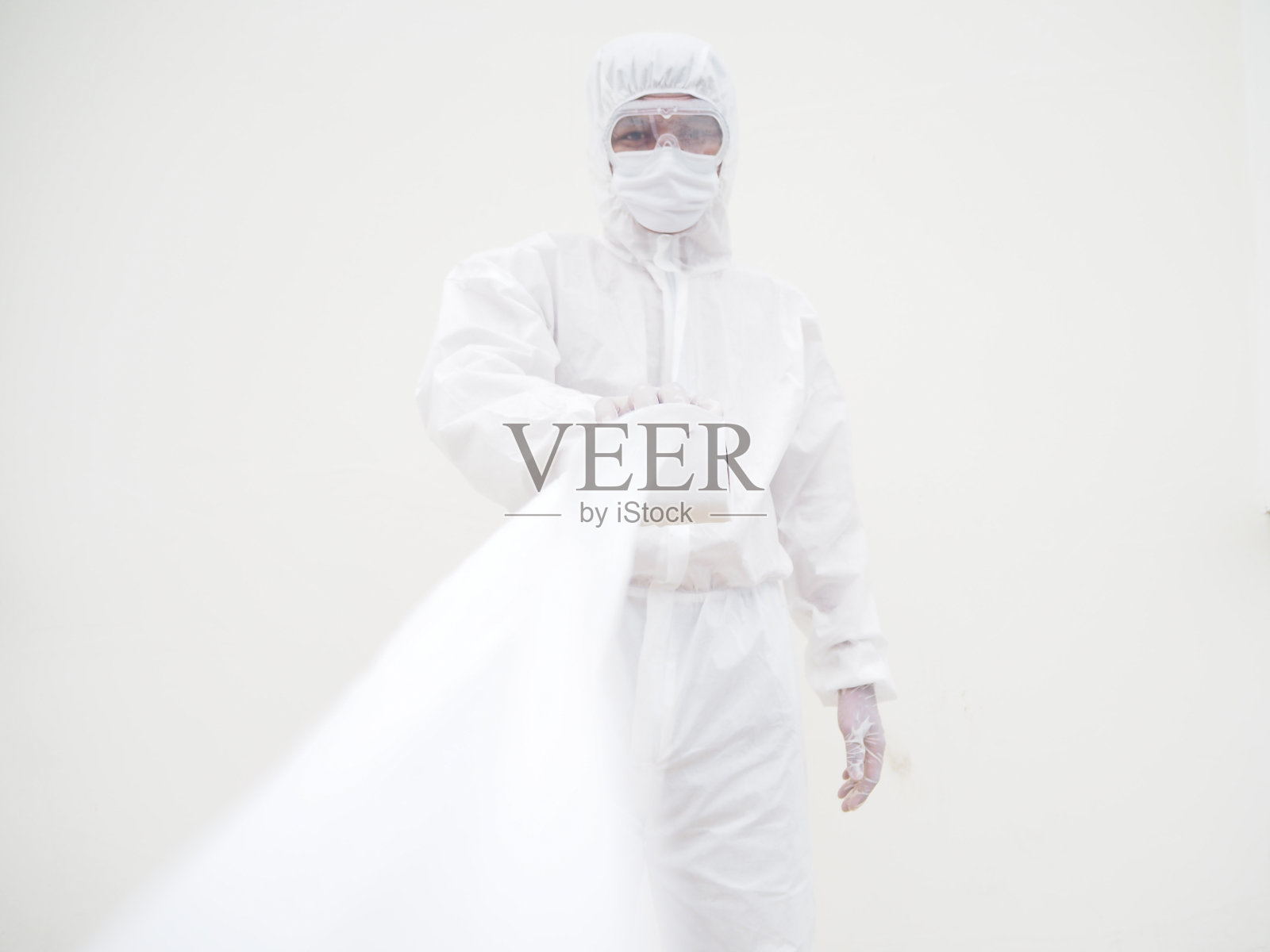 亚洲男医生或科学家穿着个人防护装备制服拿着卫生纸。在隔离新冠病毒时缺少卫生纸。COVID-19概念孤立白色背景照片摄影图片