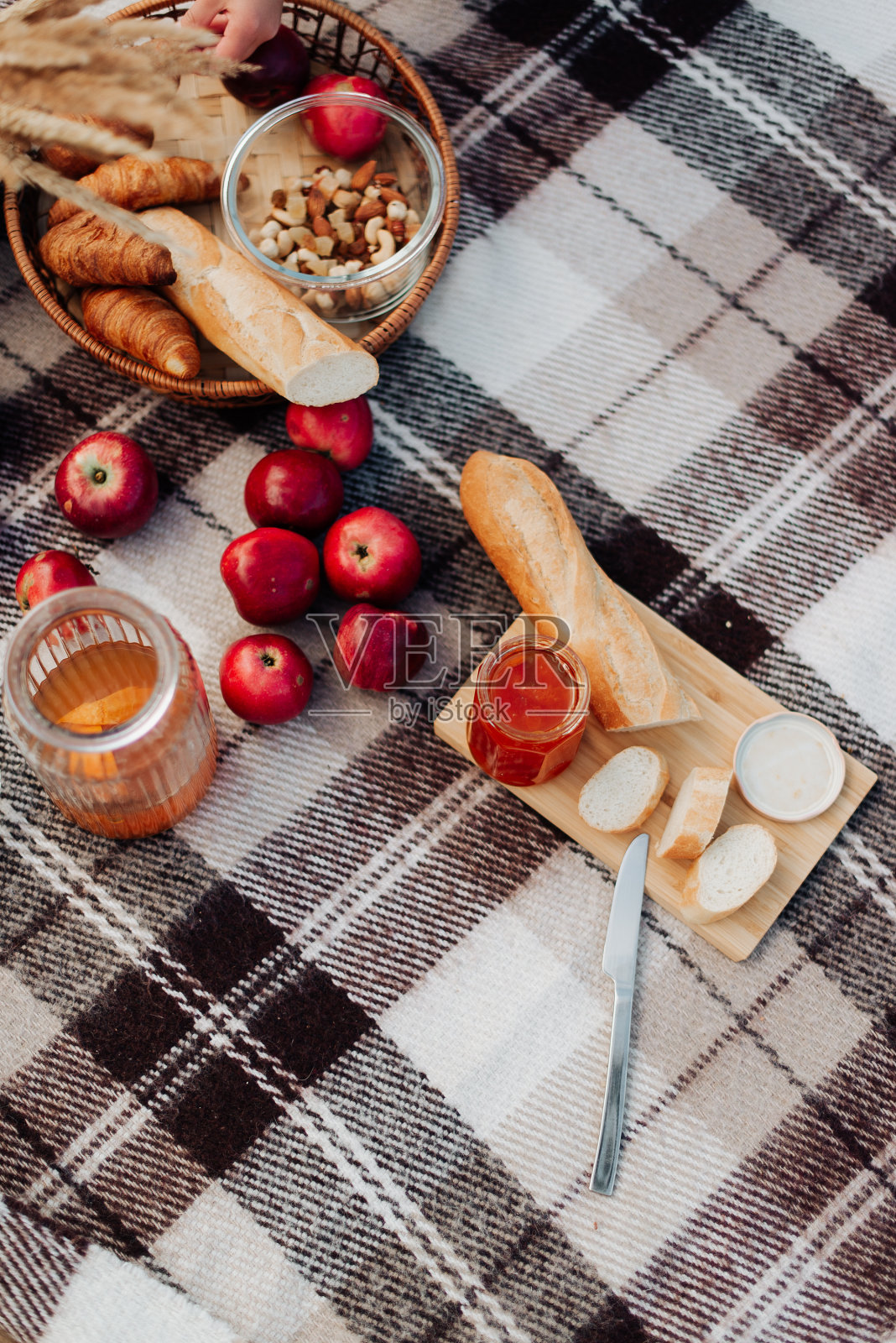 苹果，长棍果酱和坚果特写在格子毯子上照片摄影图片