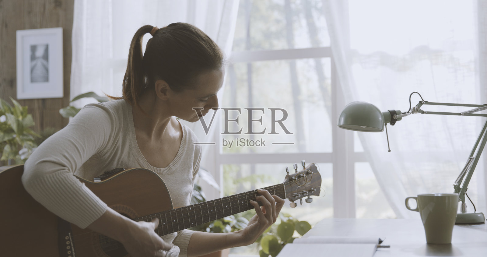 在家里弹吉他作曲的女人照片摄影图片