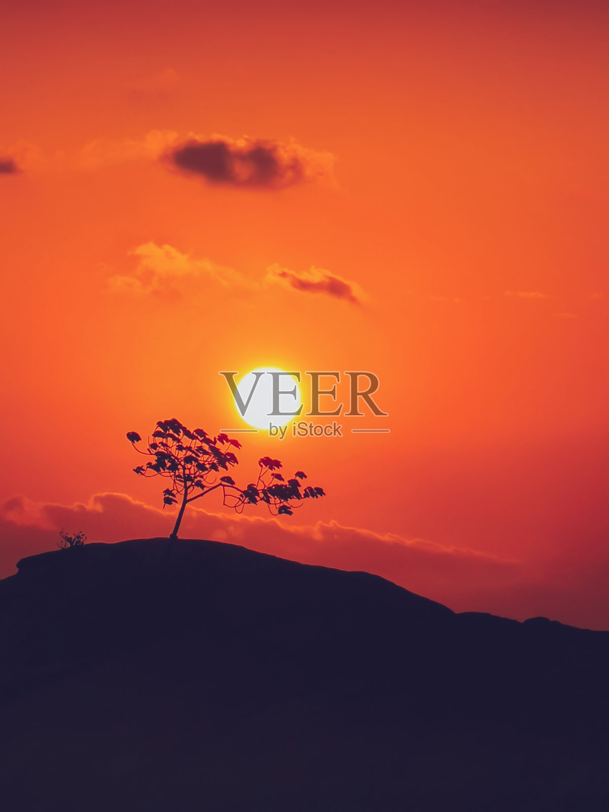 明亮的红色日落与树的剪影在岩石的石头，帕岸，泰国照片摄影图片