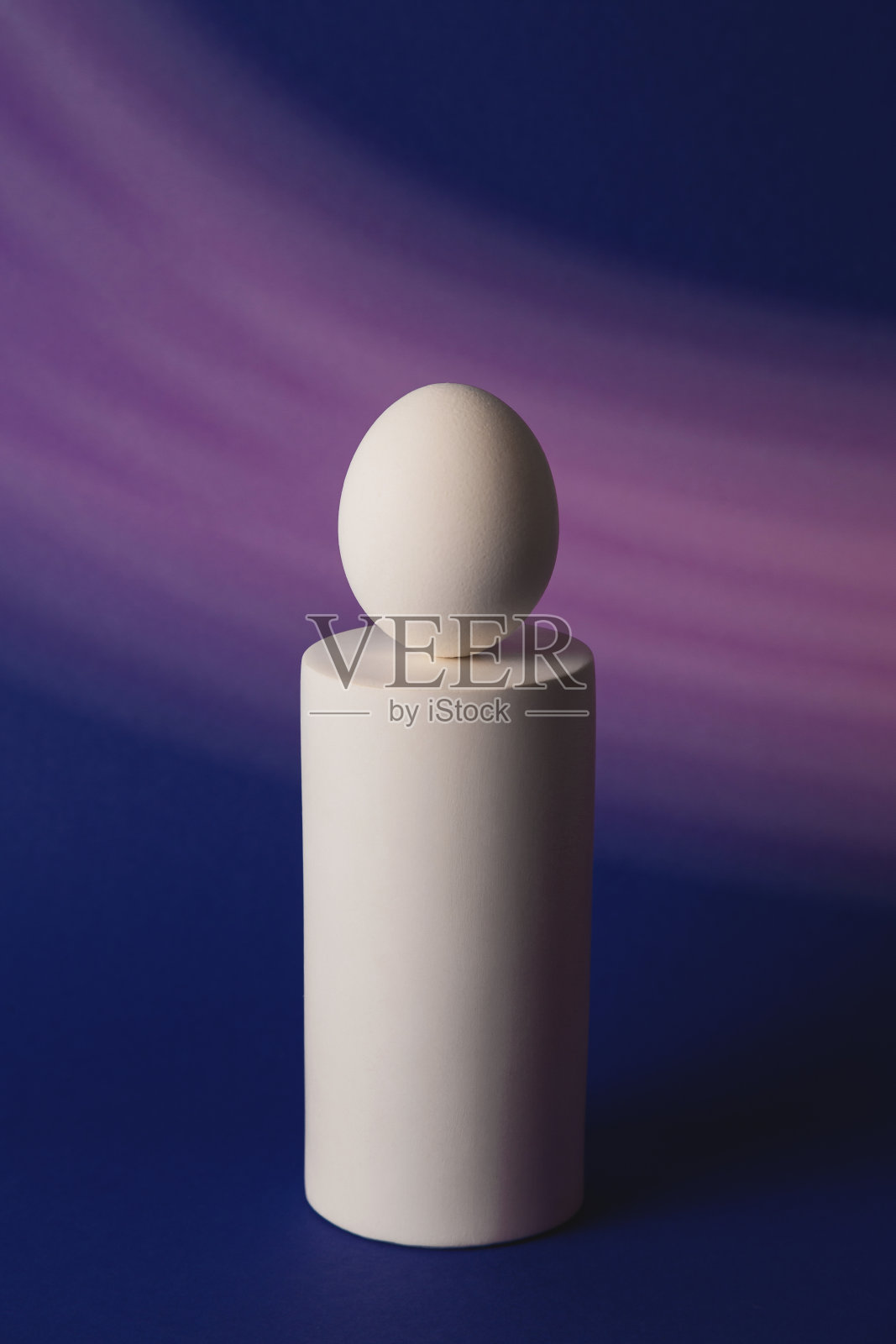 在霓虹灯和紫色的灯光下，讲台上的白色复活节彩蛋照片摄影图片