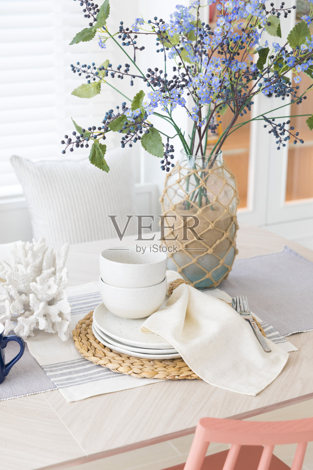 家庭餐厅室内装饰白色桌布和花瓶鲜花。照片摄影图片