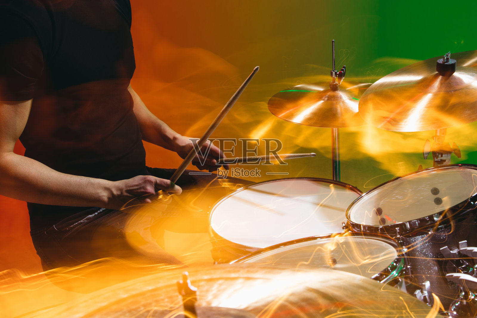 特写的男性的手打鼓孤立在绿色的红色背景霓虹灯照片摄影图片