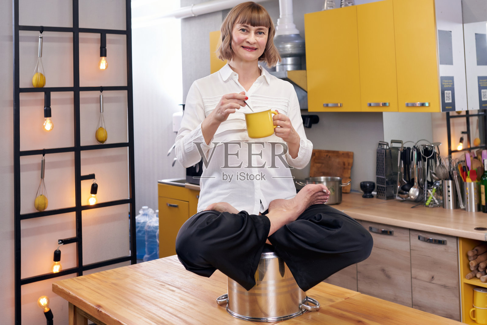 有魅力的女人坐在荷花姿势在厨房照片摄影图片