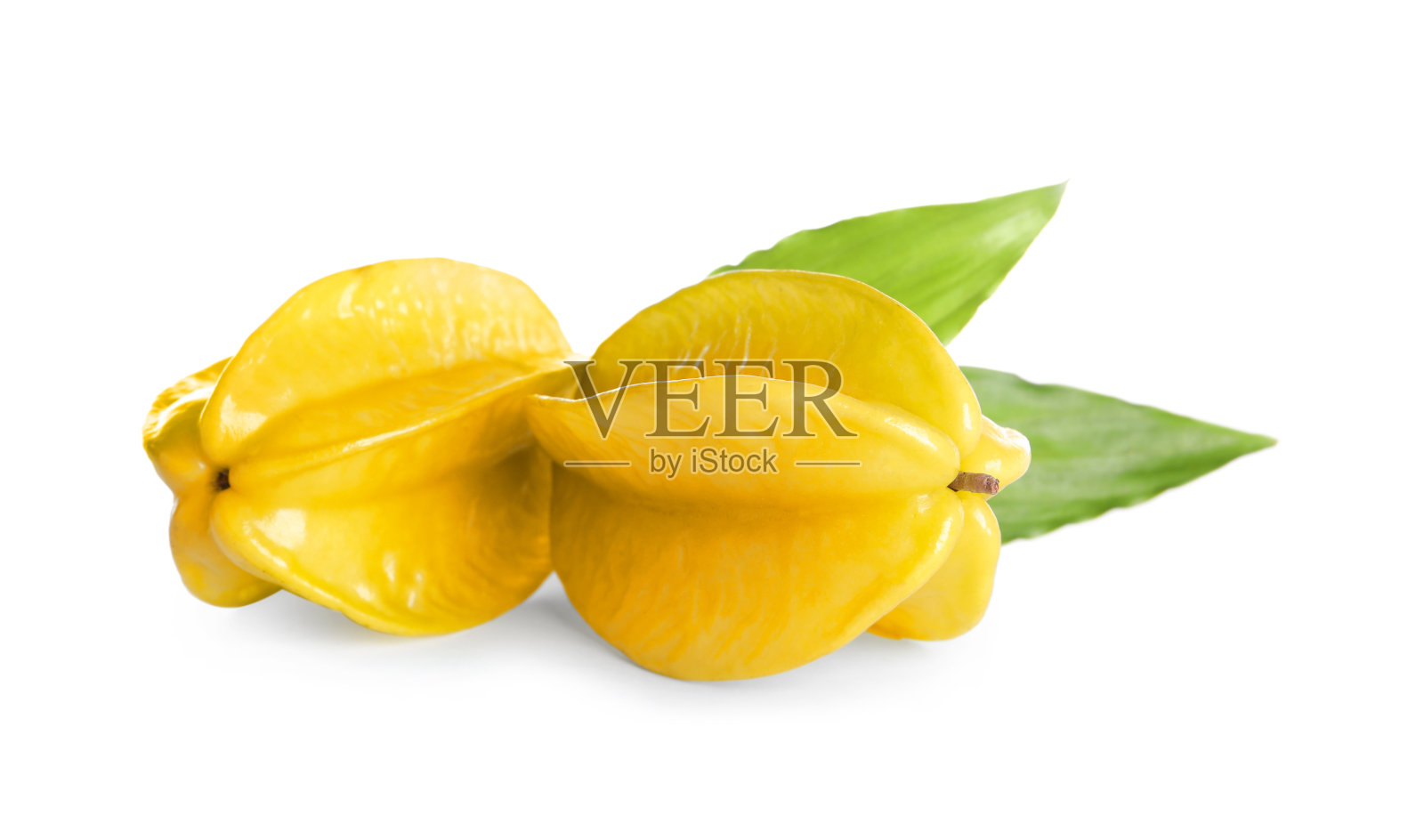 成熟的杨桃，绿叶白底照片摄影图片