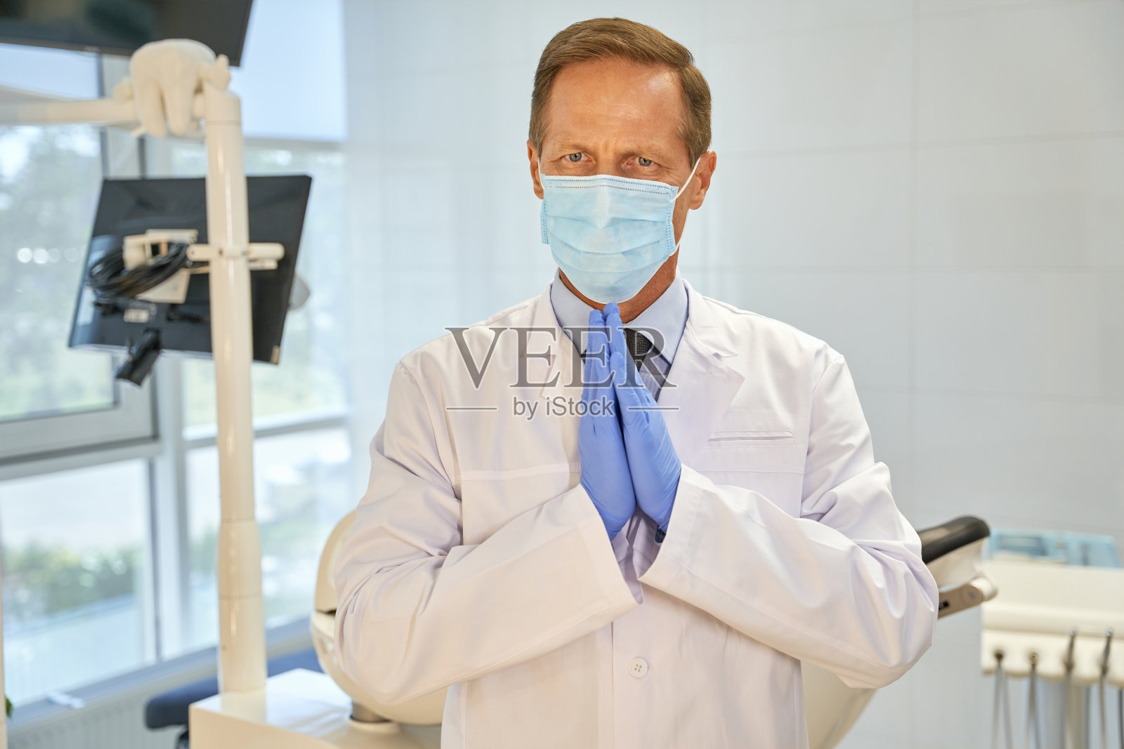 表情丰富的牙医用双手做着恳求的手势照片摄影图片