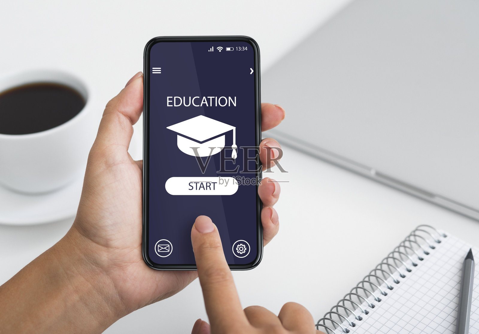 远程学习。在办公室里用智能手机浏览教育应用程序的陌生女人照片摄影图片