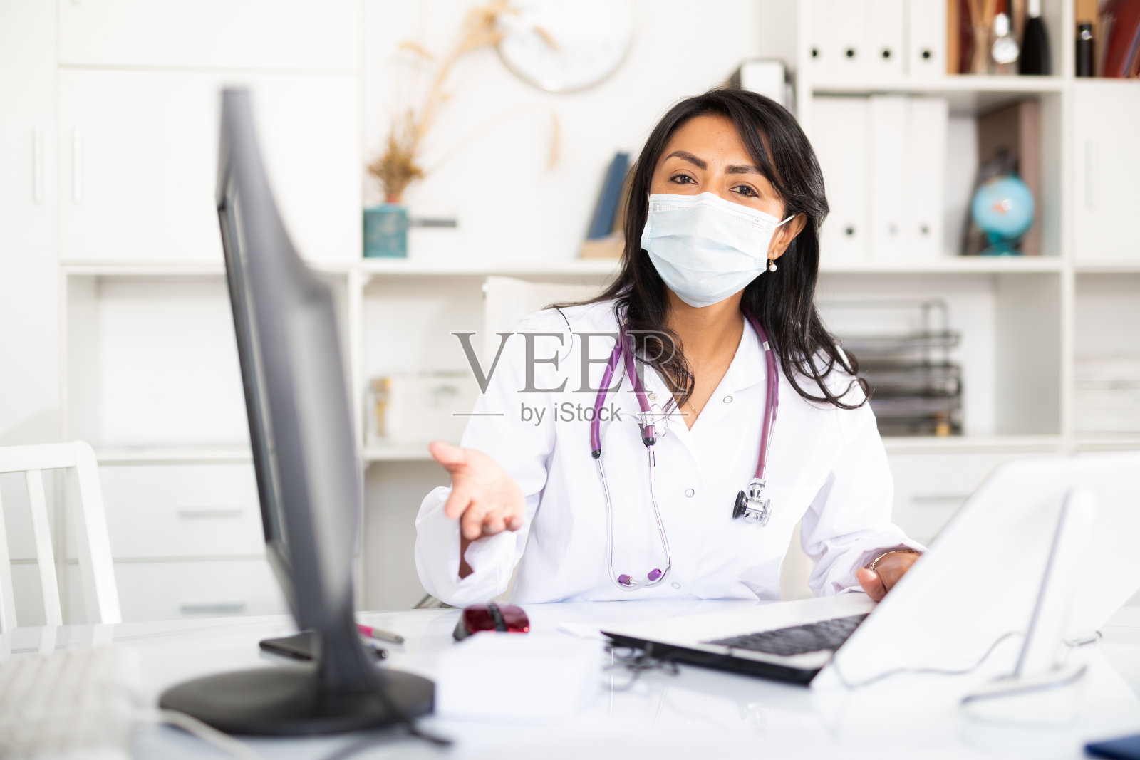 女医生戴着口罩站在doctorâ的房间进行预防的肖像照片摄影图片