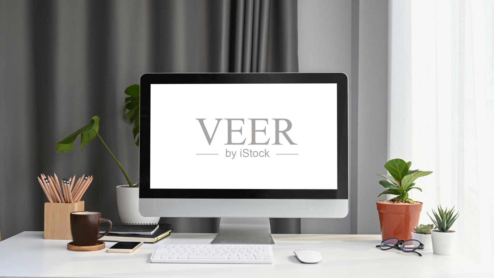 前视图模拟电脑与空白屏幕，家庭植物和办公用品在白色办公桌上。照片摄影图片