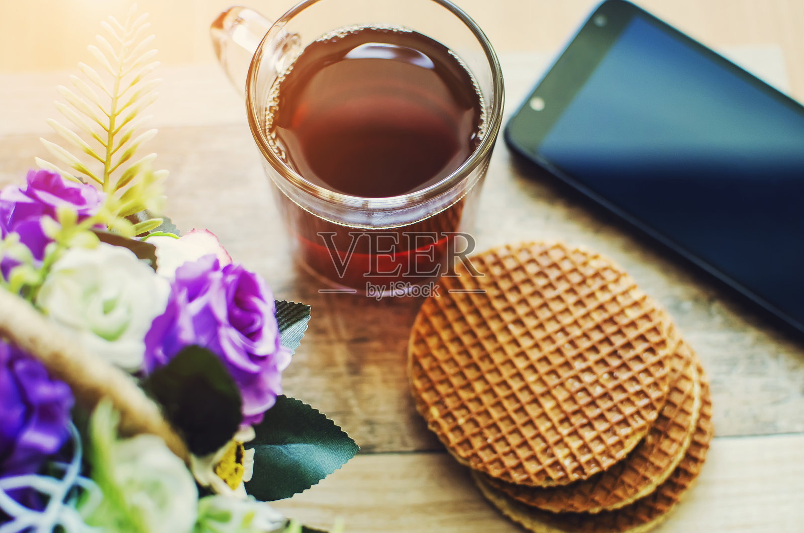 茶点、饼干和一部电话在一张木桌上。照片摄影图片