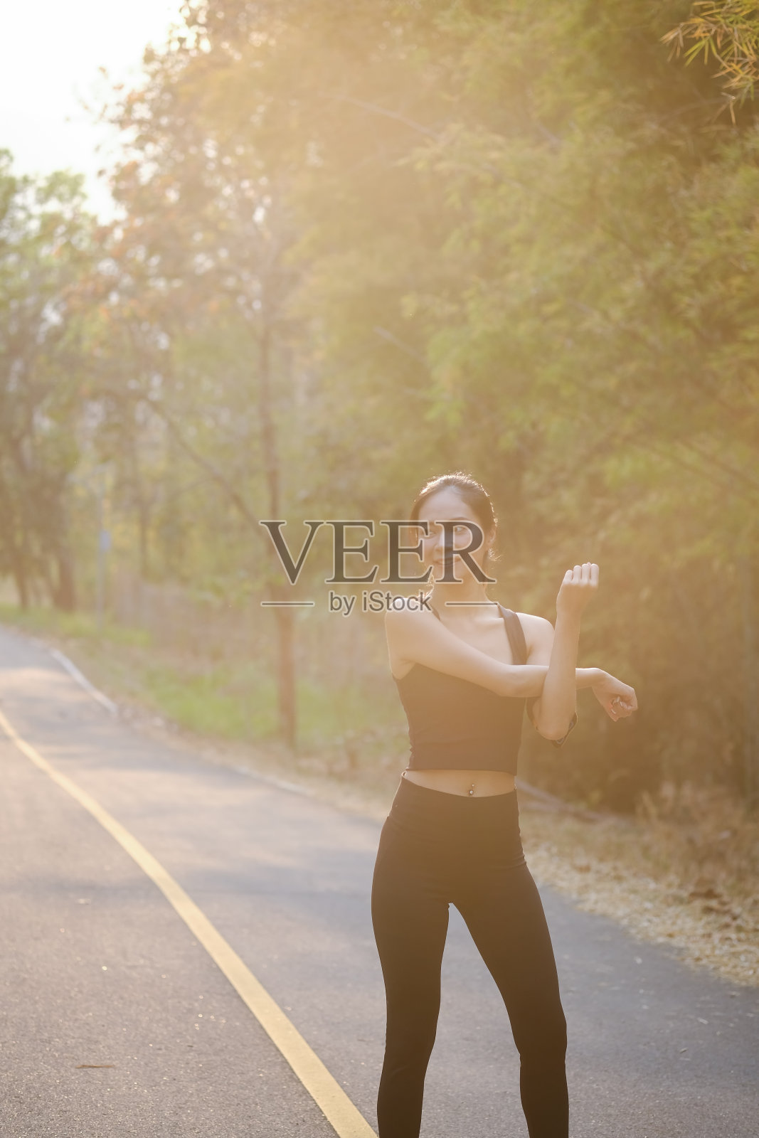 女运动员在公园慢跑前伸展的肖像。照片摄影图片