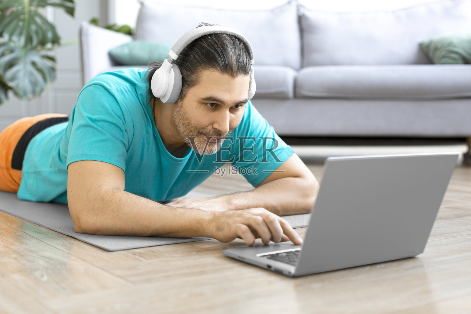 一个中年男子给他的教练打在线视频电话的特写。他正在为在线健身做准备照片摄影图片