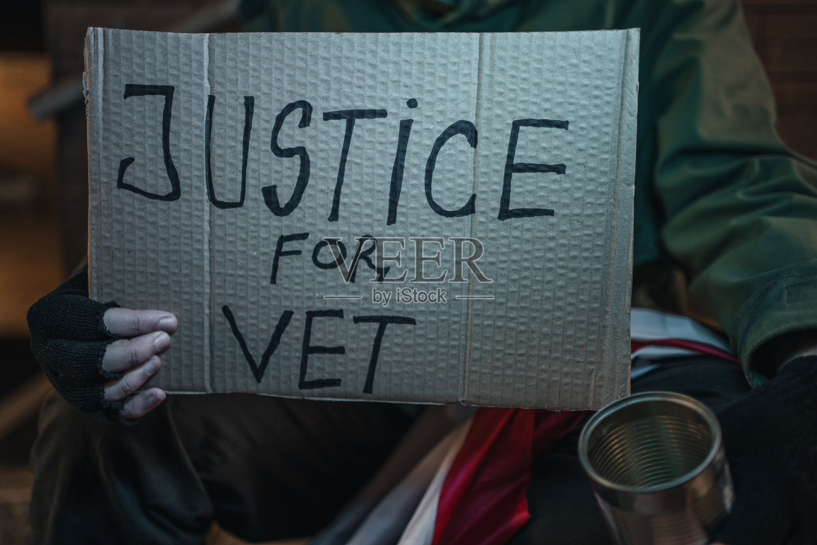 退伍军人在街上乞讨，手里举着一个写着“兽医正义”的牌子照片摄影图片