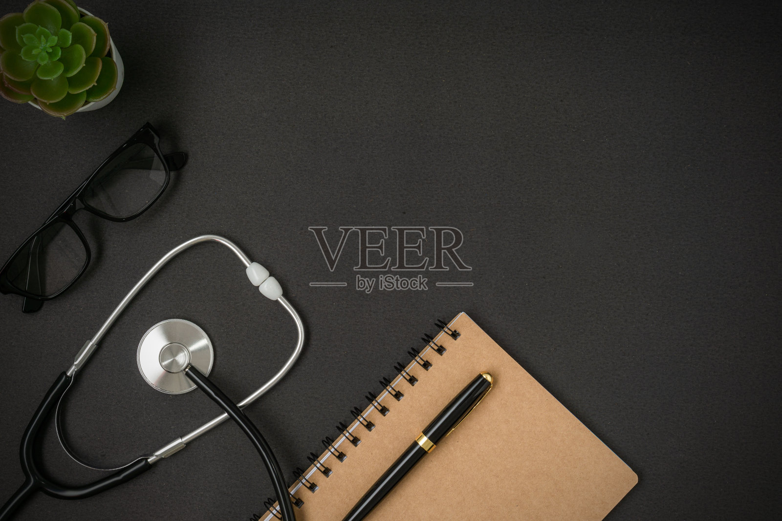 一个听诊器和笔记本在黑色的背景和副本空间。平的。照片摄影图片