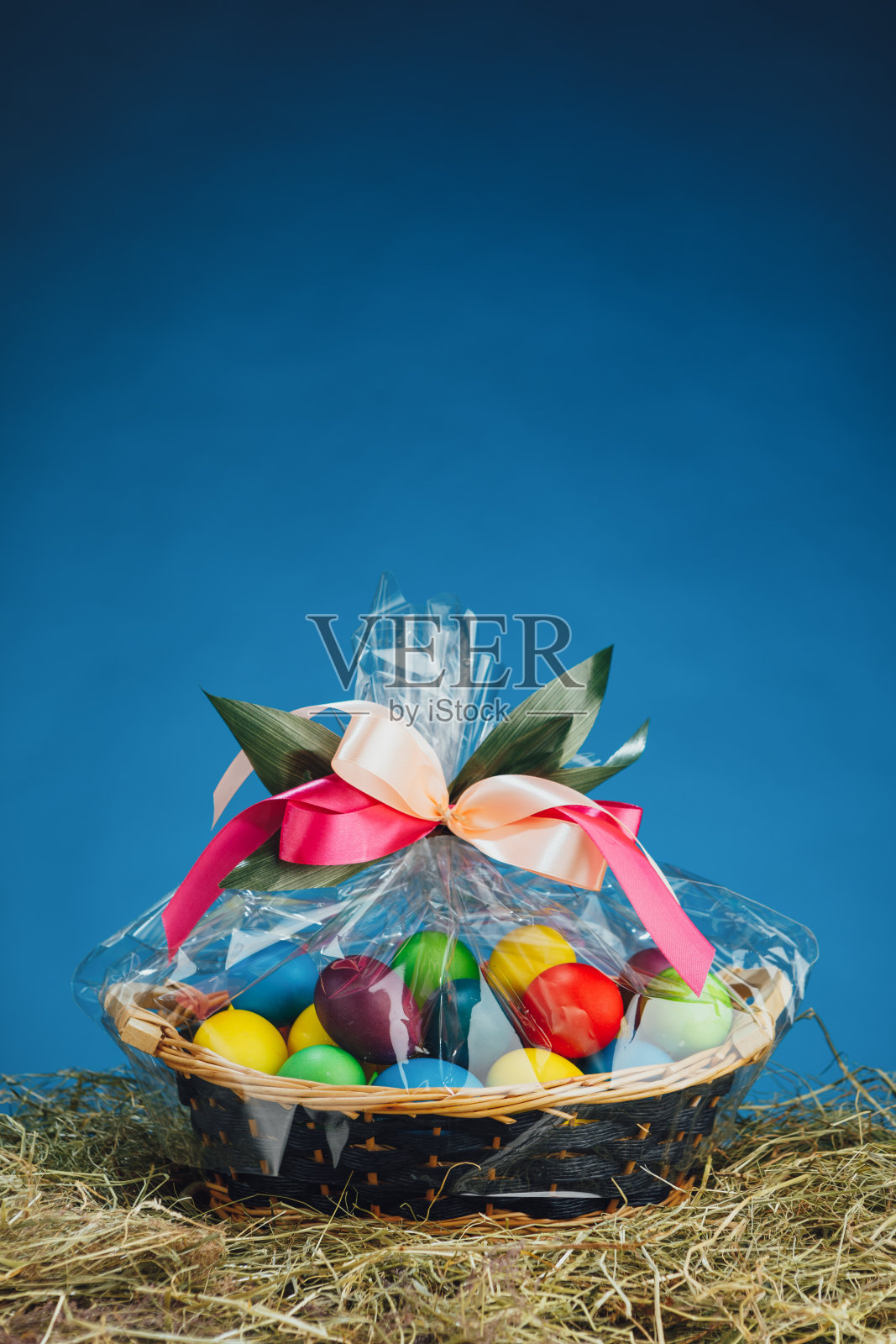 复活节礼品篮，多颜色的鸡蛋，蓝色的背景照片摄影图片