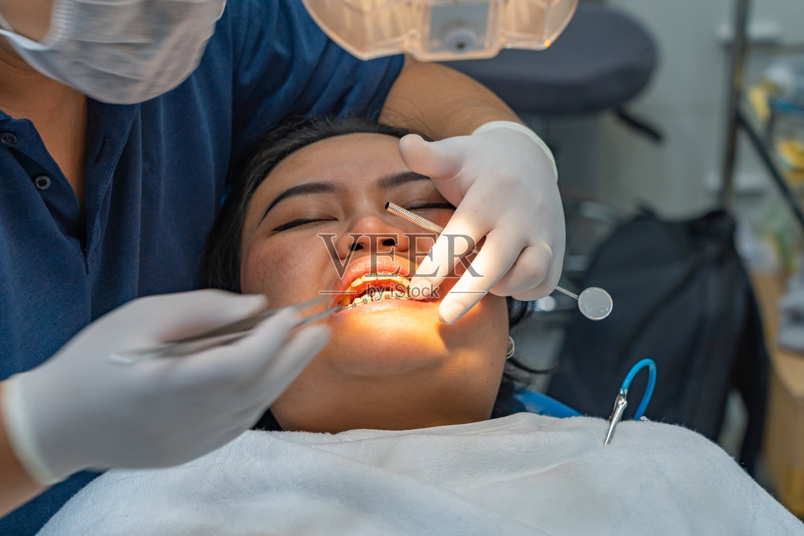 牙科医生或正畸医生为女病人检查牙套照片摄影图片