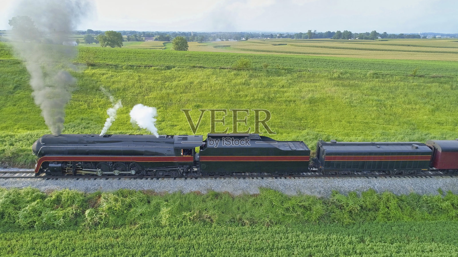 一辆老式蒸汽机车在农田里喷烟和蒸汽08照片摄影图片