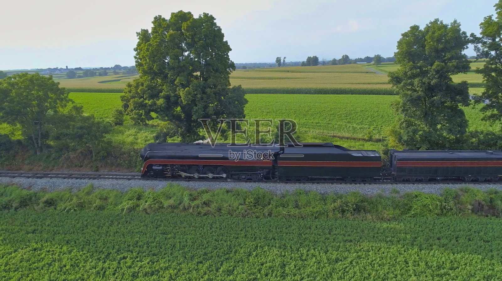 一个古董恢复蒸汽机车吹烟和蒸汽旅行通过农田的观点照片摄影图片