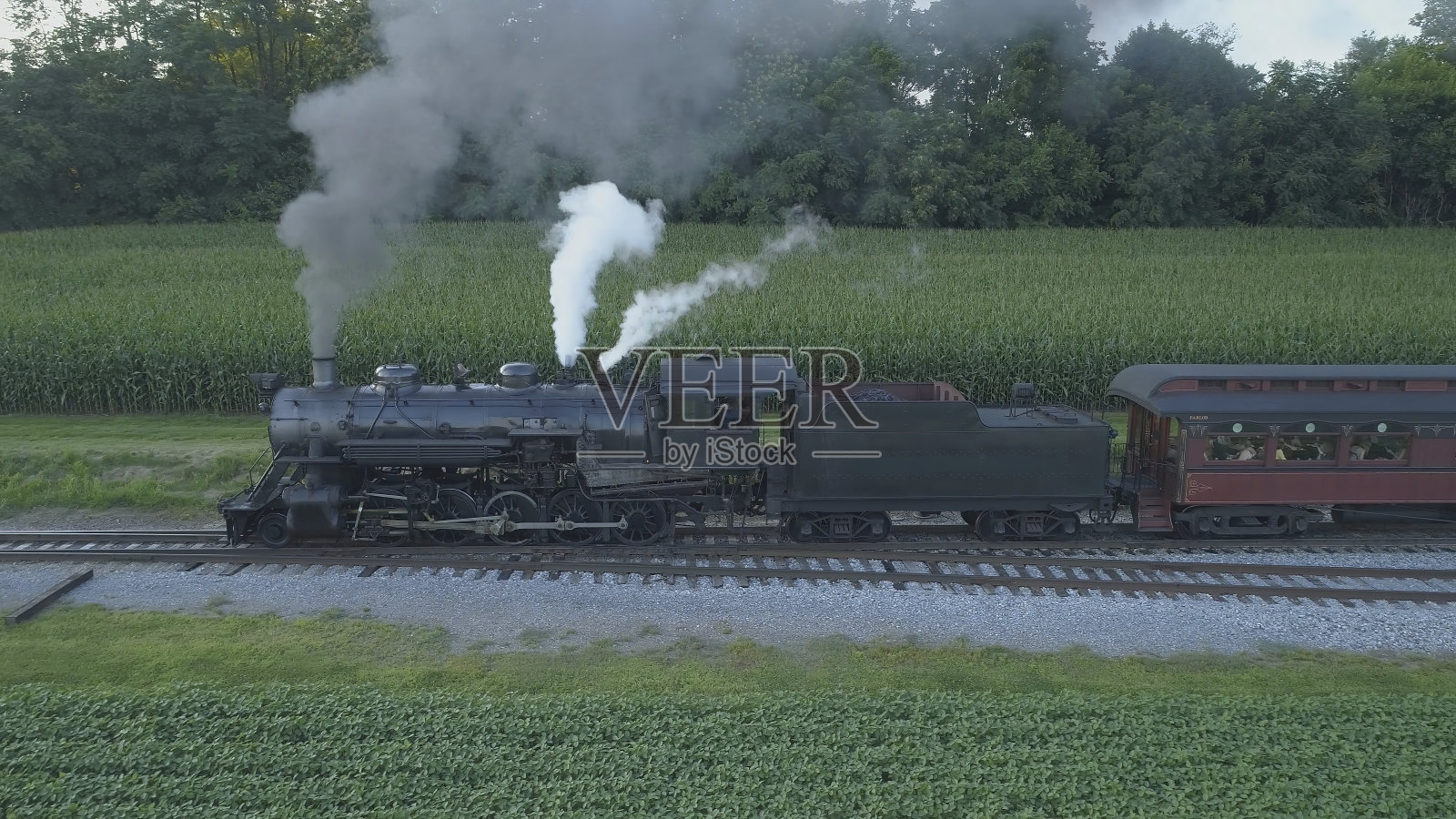 鸟瞰图的古董蒸汽机车吹烟和蒸汽旅行通过农田照片摄影图片