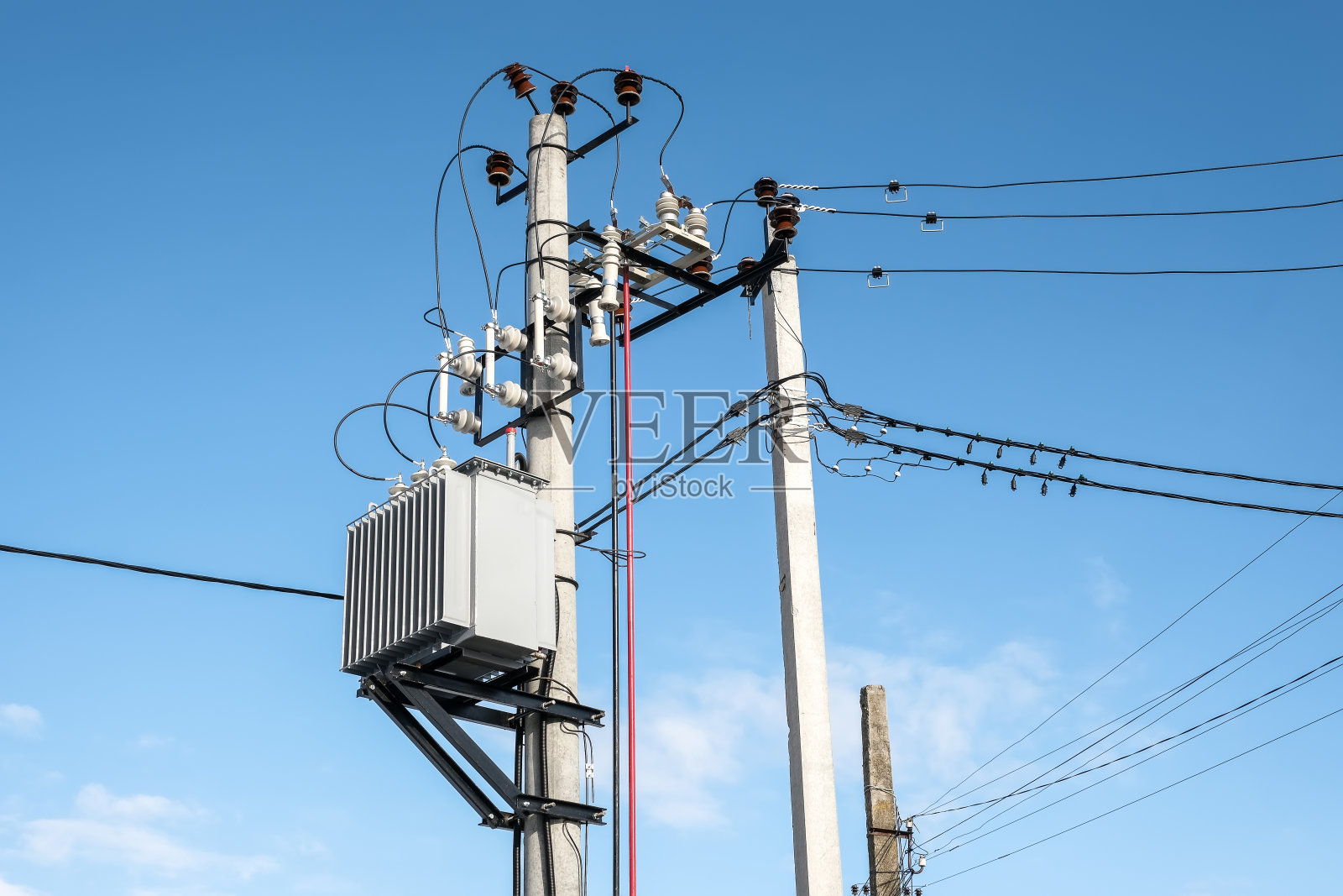 变压器安装在一根杆子上，背景是蓝天照片摄影图片