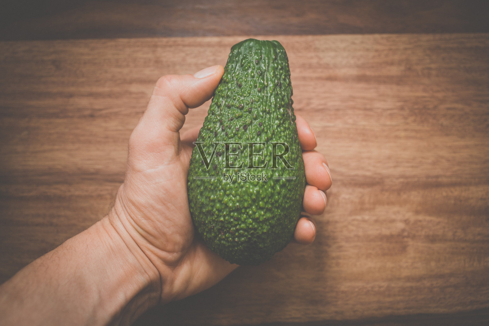 一只手拿着鳄梨的特写照片摄影图片