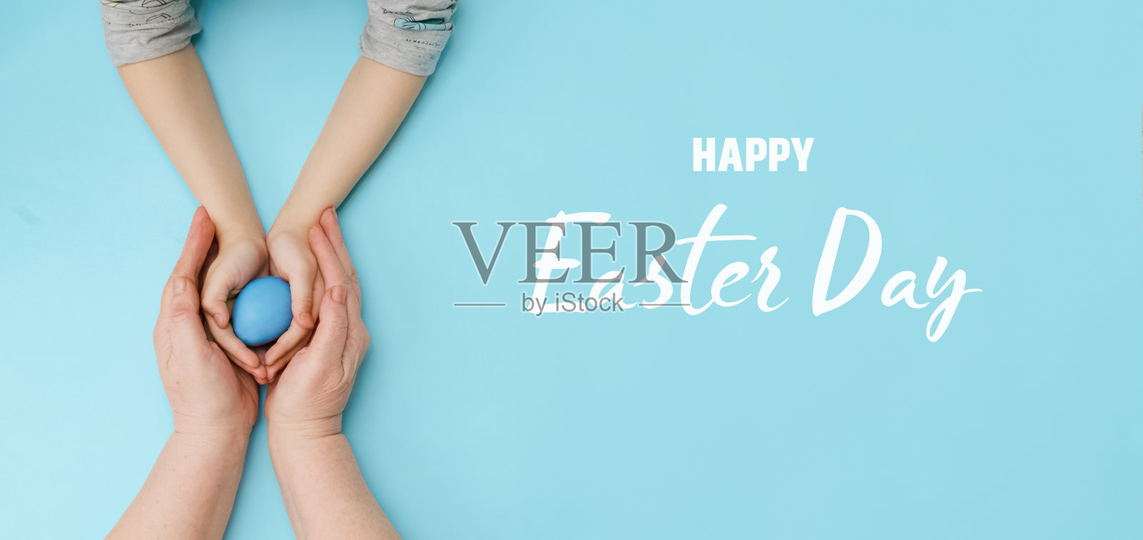 复活节快乐。一个小女孩和她的妈妈或奶奶在蓝色的背景上一起拿着彩色的复活节彩蛋。为春节做准备。照片摄影图片