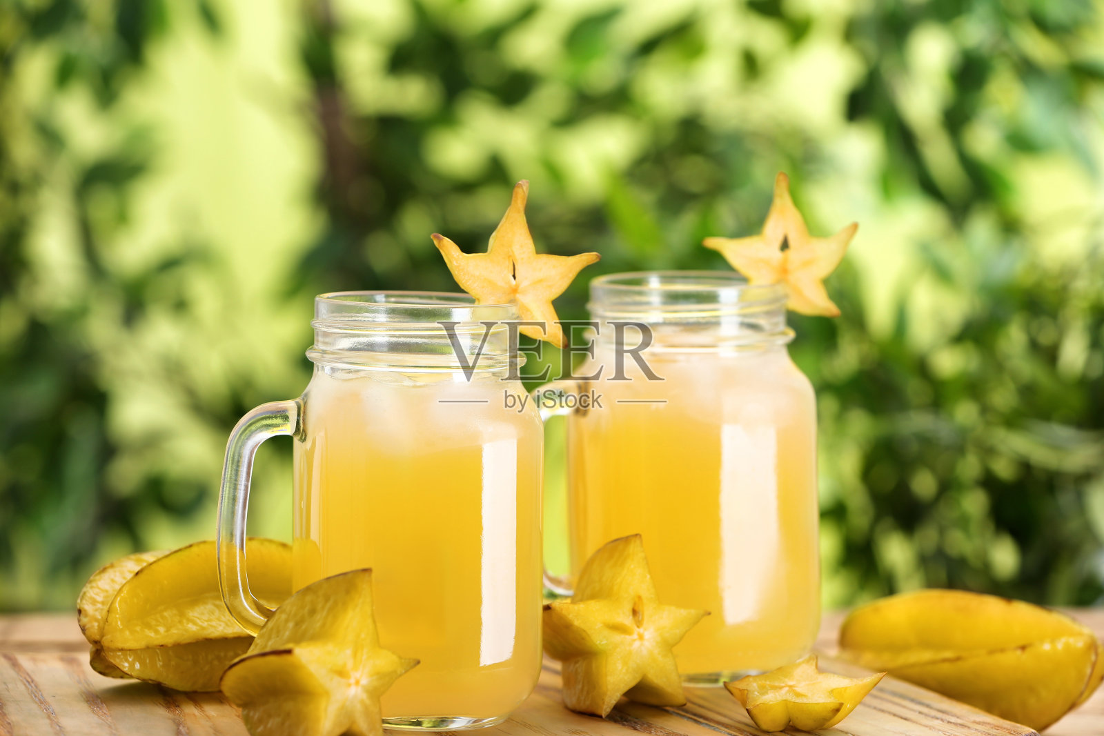 美味的杨桃汁和新鲜的水果在木板上对模糊的背景，特写照片摄影图片