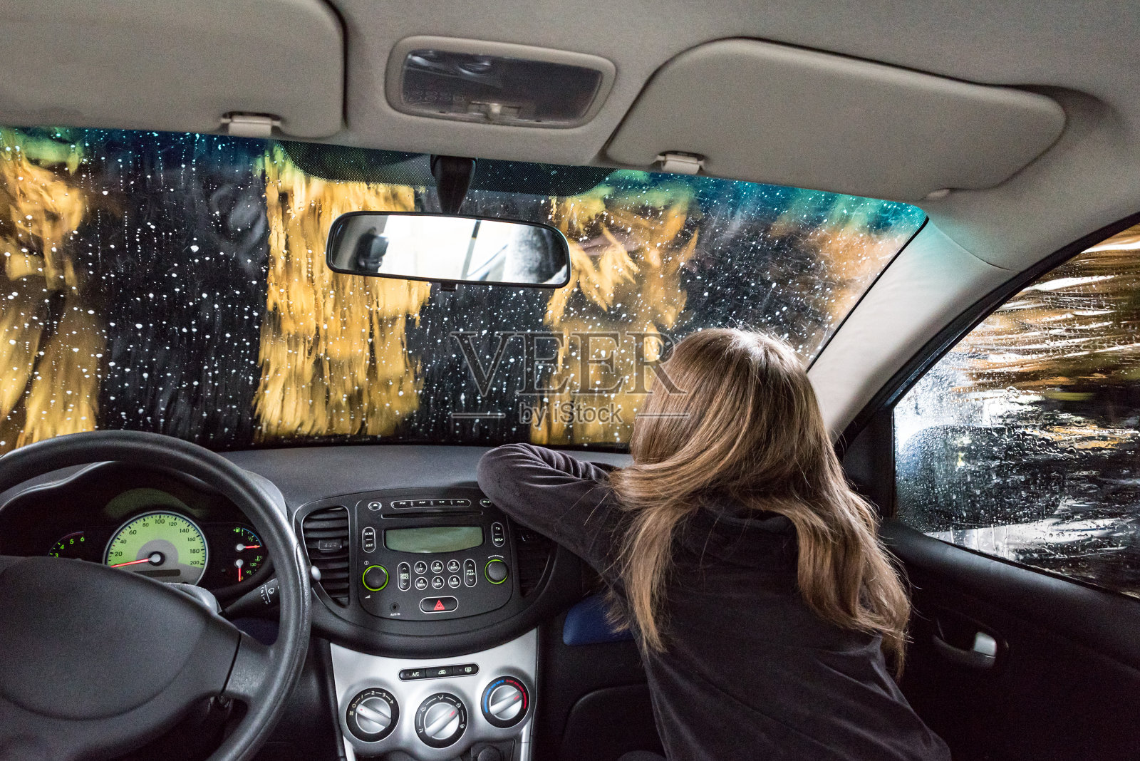 好奇的女孩在车里通过自动洗车照片摄影图片